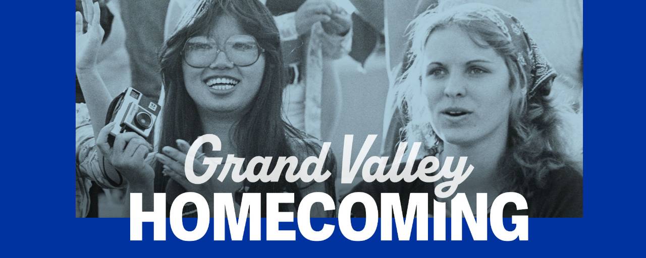 Students smile in the stands at a football game with text Grand Valley Homecoming